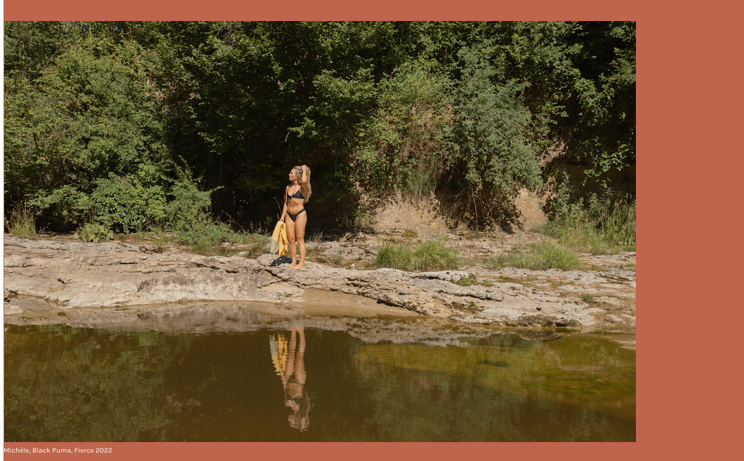 blond girl standing on a lake in a black bikini